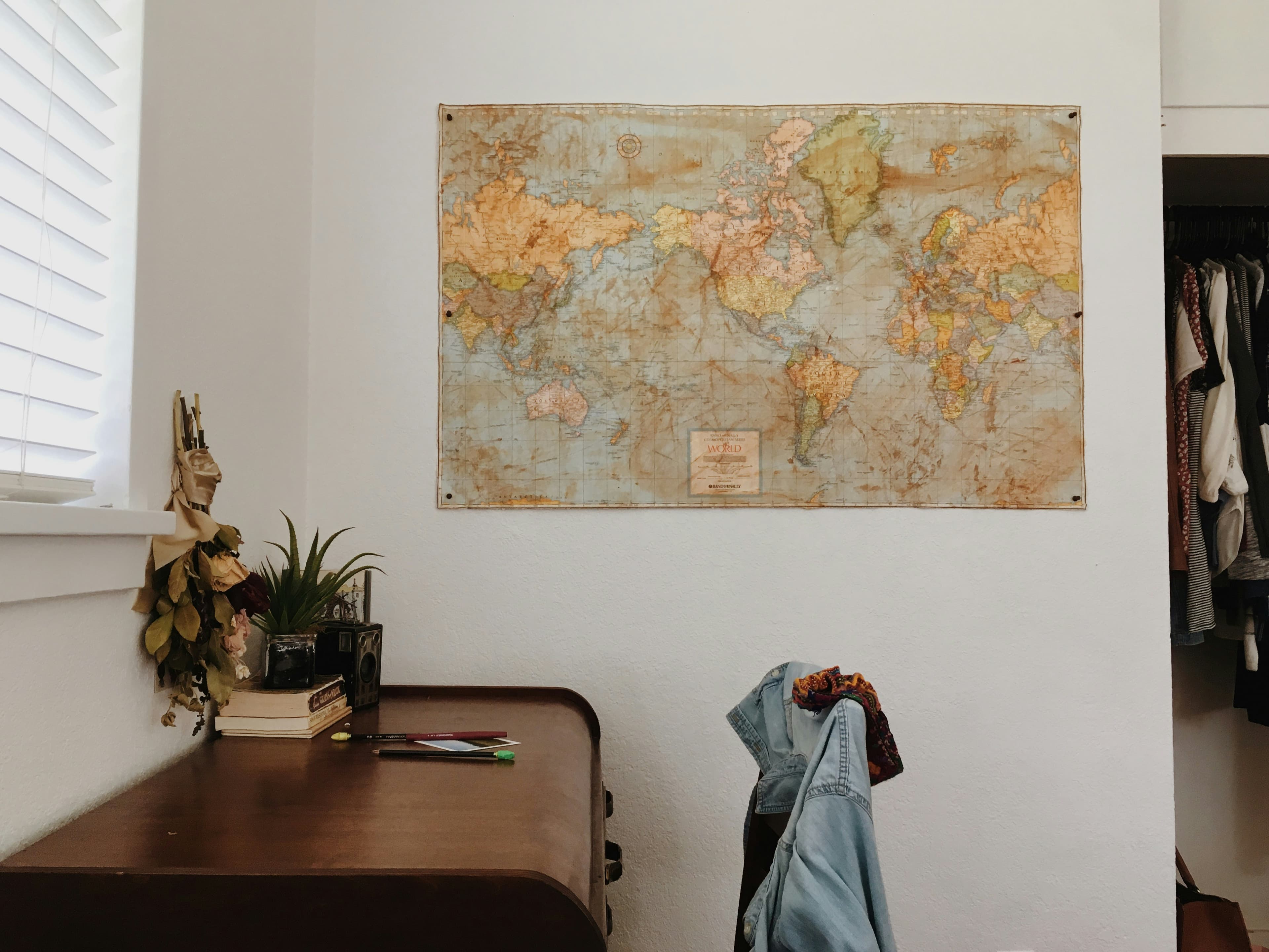 World map hanged on a wall near brown desk